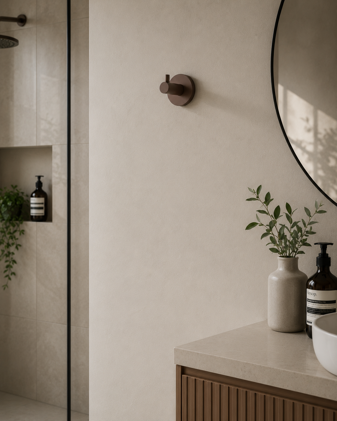 Bathroom interior with a round mirror, plant, and toiletries.
