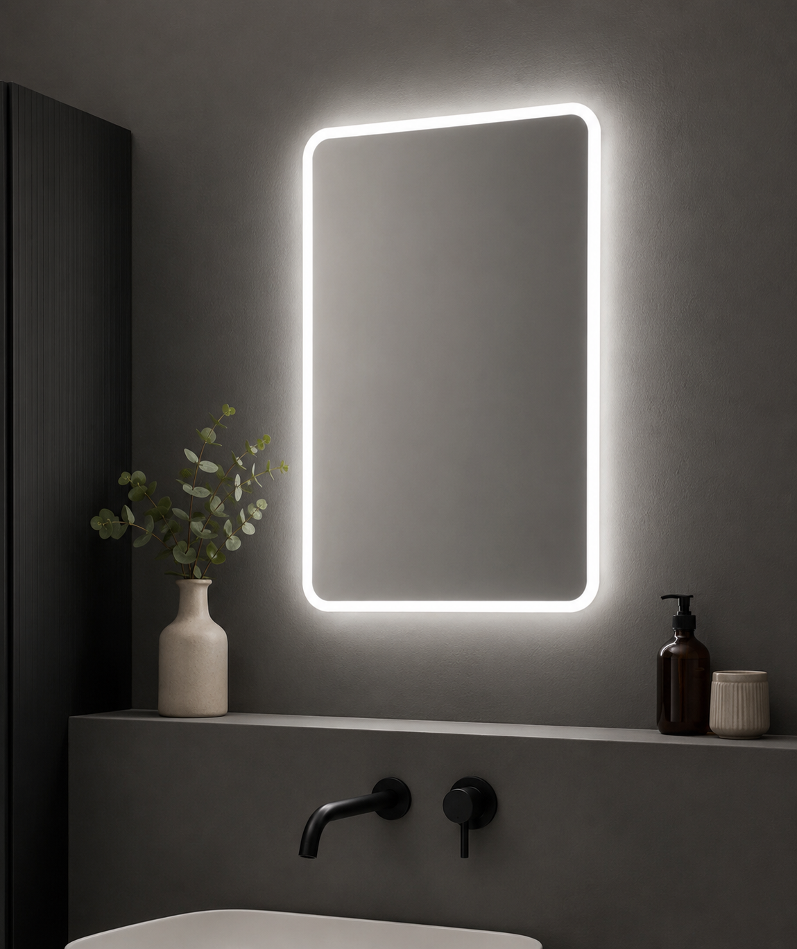 Bathroom vanity with a illuminated mirror, plant, and toiletries.