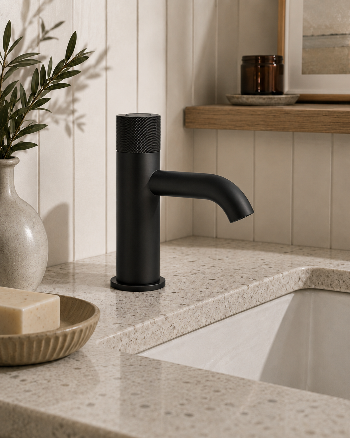 Black faucet on a bathroom sink with decorative elements.
